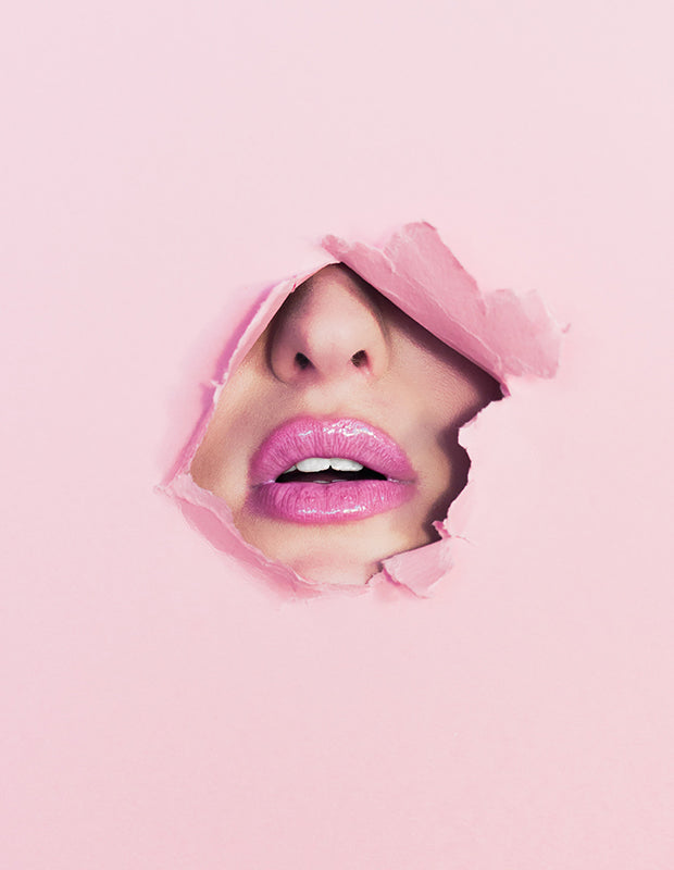 lips with bright pink lipstick bursting through fun pink paper