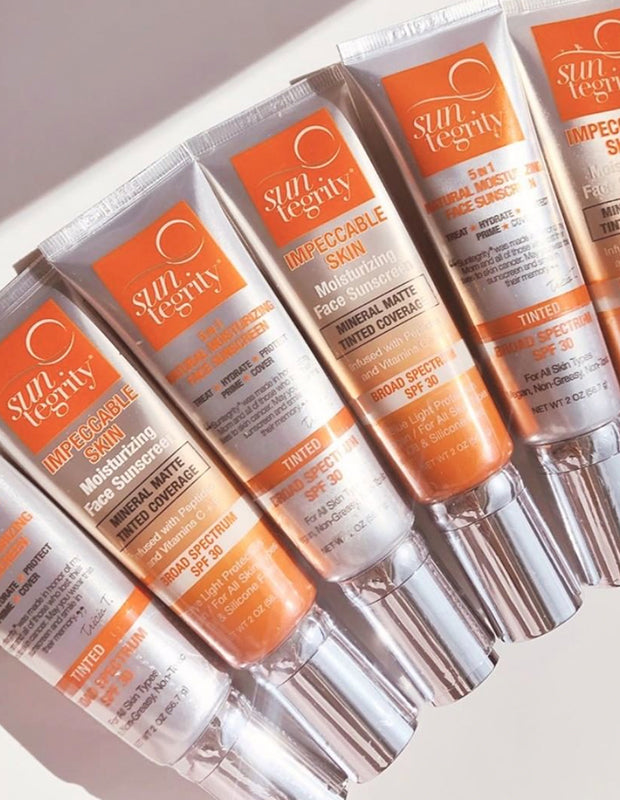 Suntegrity all natural sunscreen tubes lined up on a white table